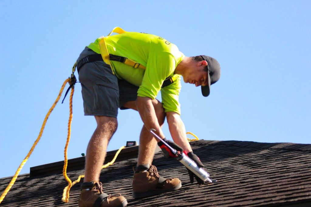 Roofers inspecting a flat commercial roof with visible seams and surface wear under bright daylight.