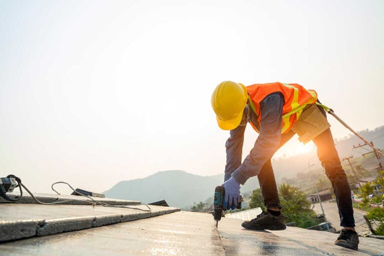 A building manager examines a ceiling water stain beneath a commercial roof leak.